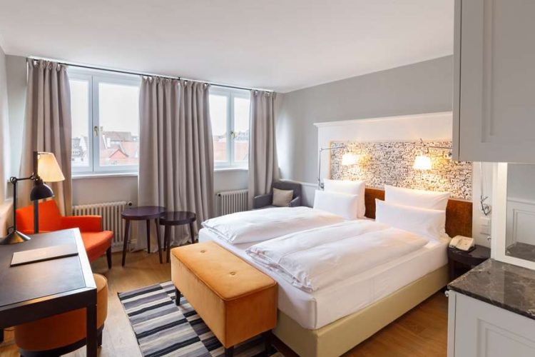 Double room superior plus with a wide bed, wardrobe, armchair and lake view