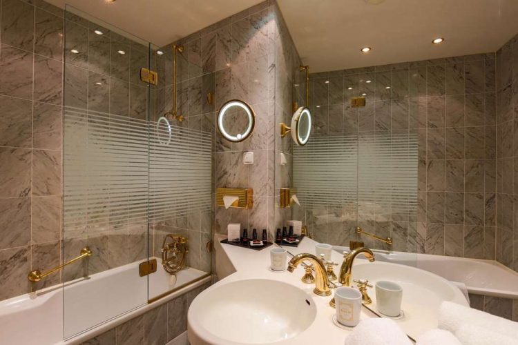 Bathroom with WC, washbasin, bathtub, make-up mirror and hairdryer