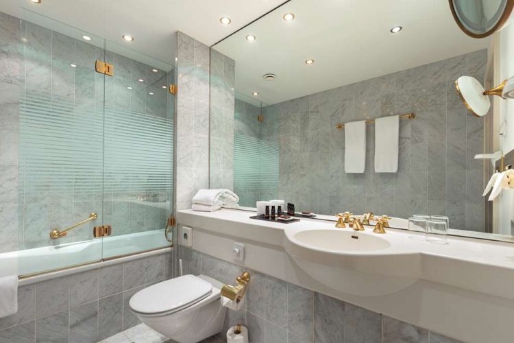 Bathroom with toilet, washbasin, bathtub, make-up mirror and hairdryer